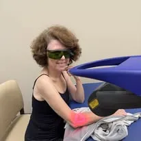 Patient receiving shockwave therapy on elbow wearing protective goggles