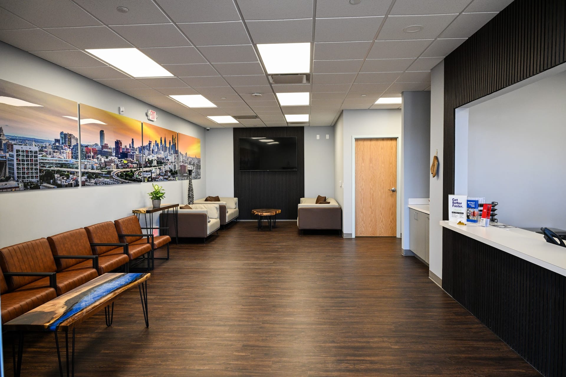 Modern medical office waiting room with leather chairs and city skyline artwork